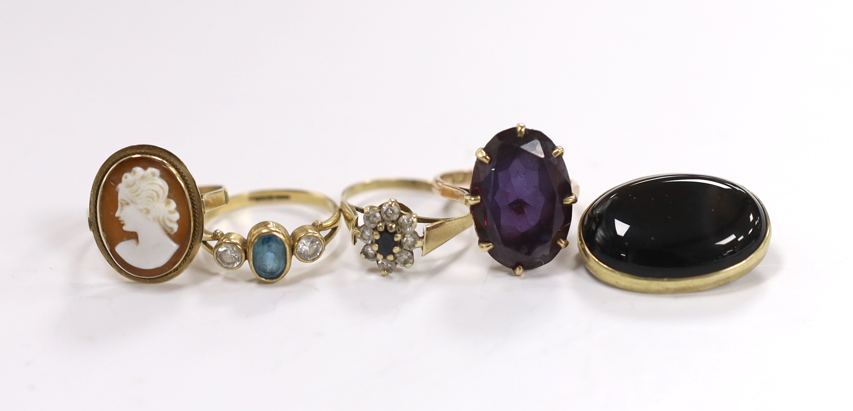 Two 14k and gem set rings, including cameo shell and synthetic colour change corundum, two 9ct gold and gem set rings and a cabochon set yellow metal oval brooch.